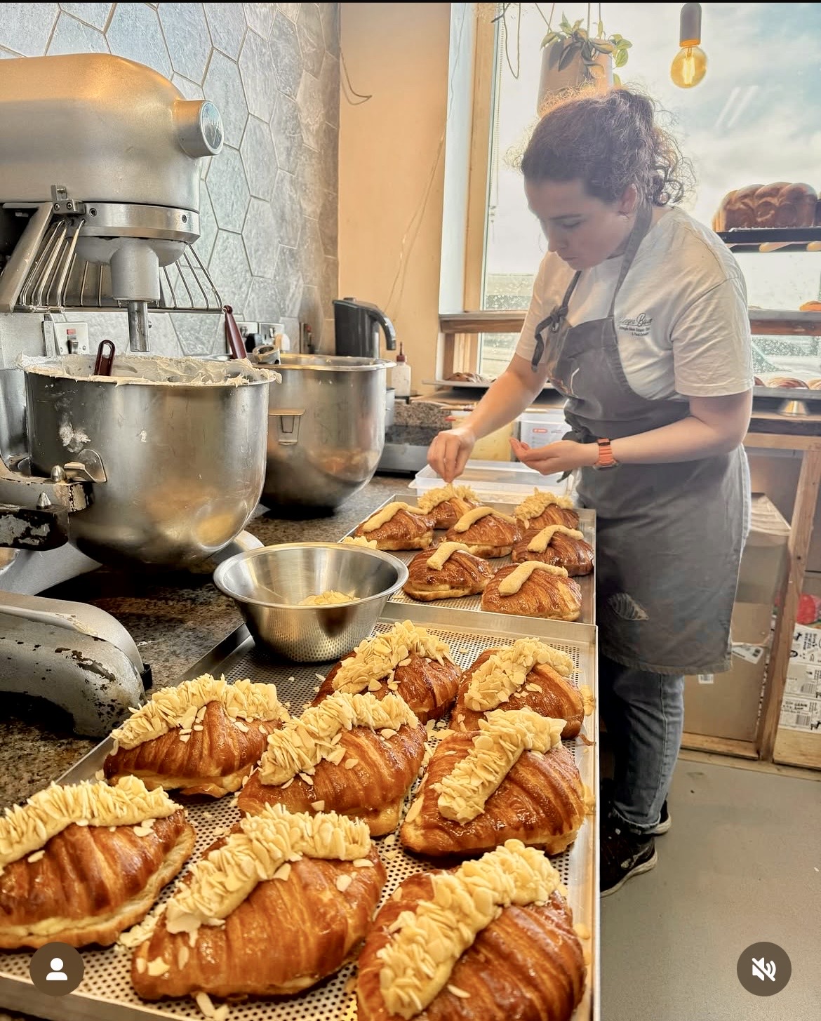Baker piping cream onto fresh croissants in the kitchen